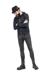 Happy spontaneous laughing hipster with fedora hat looking down. Full body length portrait isolated...