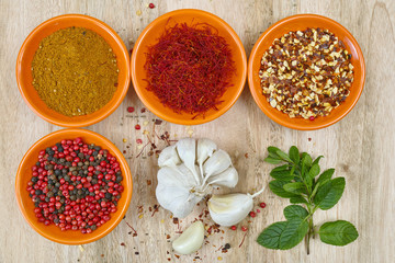 Four bowls with saffron, pepper, ras en  hanout, fresh mint and