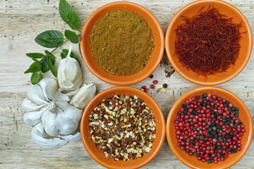 Four bowls with saffron, pepper, ras en  hanout, fresh mint and