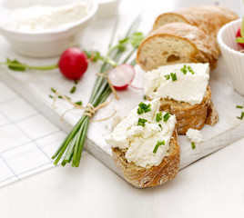 Canapes with curd cheese and fresh chive on a white table