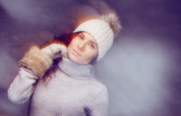 A girl in warm winter sweater and a hat.