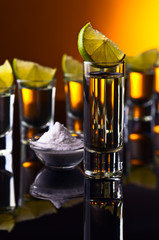 Gold tequila on a black reflective background