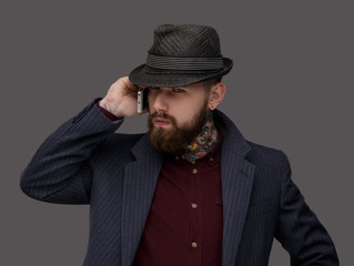 Fototapeta na wymiar Bearded man in a hat using smartphone.