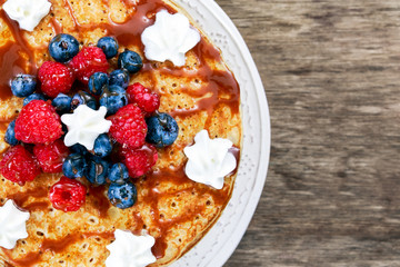 Fresh golden pancakes with raspberries, blueberries