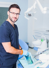 healthcare, profession, stomatology and medicine concept - smiling male  dentist over medical office background