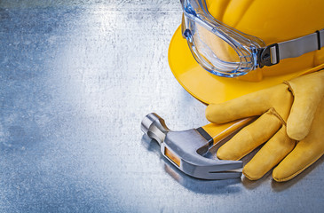 Protective glasses gloves building helmet claw hammer on metalli