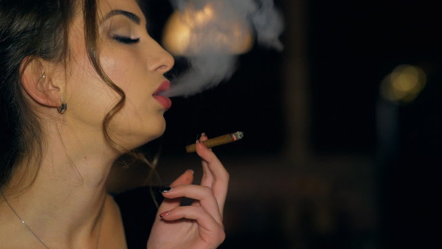 young beautiful brunette girl smoking a cigarette at the restornant