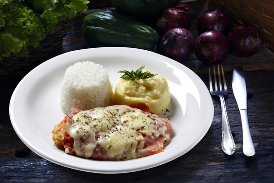 The steak parmigiana with potato and rice