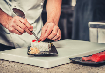 male cooks preparing sushi