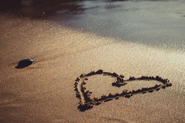 Heart drawn on sand sea beach