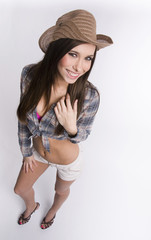 Cowgirl stands wearing cowboy hat