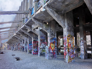 Fototapeta na wymiar Abandoned cyanide factory with cement columns and graffiti - landscape photo