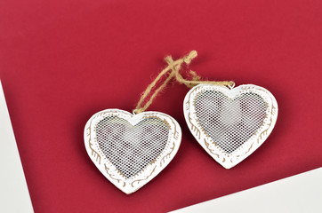 Two tied hearts   /  Two white hearts tied with string on a red background