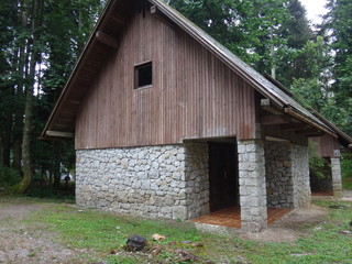 Небольшой каменный домик в лесу летним днем