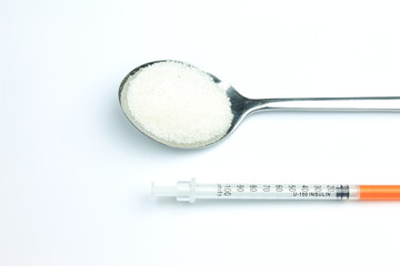 Fototapeta na wymiar Little insulin syringe and spoon with sugar 