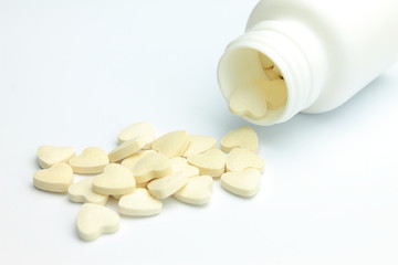 Bottle of yellow pills in the shape of hearts 