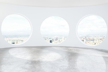 Light loft room with round windows and concrete floor