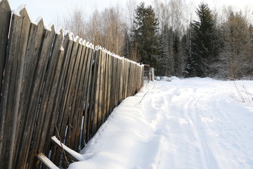 Снежная дорога, идущая вдоль деревни в зимний день