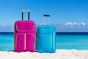 Two suitcases on sandy tropical beach