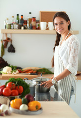 Young woman standing near desk in the kitchen