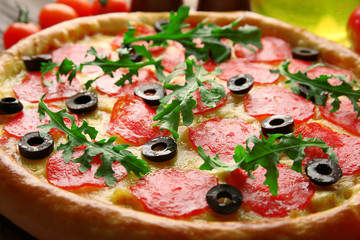 Tasty pizza with salami on decorated wooden table, close up