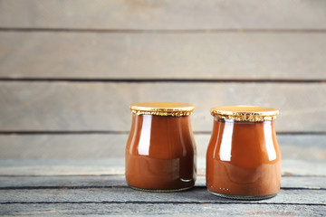 Chocolate dessert in a small glass jars on wooden background
