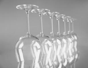 Wine glasses in a row upside down on light grey background