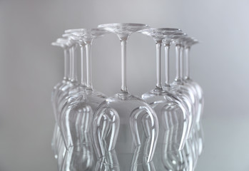 Wine glasses in a row upside down on light grey background
