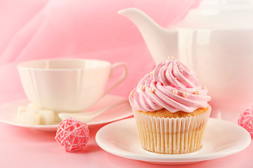 Tasty cupcakes with tea set and decorations, closeup