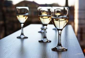 Glasses of wine on light blurred background
