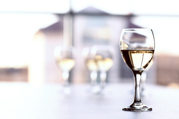 Glasses of wine on light blurred background