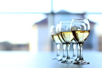 Row of wineglasses on light blurred background