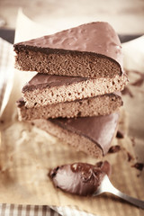Pieces of frosting chocolate cake on parchment paper