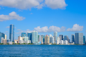Fototapeta na wymiar Colorful photo of the Miami skyline as viewed off of the coastline in Biscayne Bay, Florida on a blue sky sunny morning.