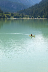 Man in yellow kayak on a wilderness lake