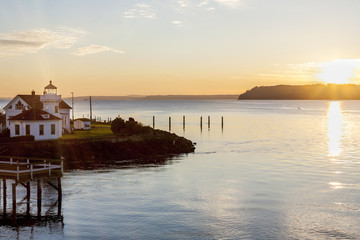 Sunset over Puget Sound and Mukilteo lighthouse with Whidbey Island in the distance - obrazy, fototapety, plakaty