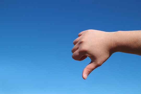 male hand bad gesture in the blue sky