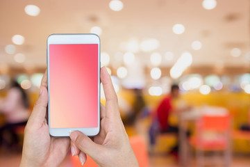 Woman's and holding smart phone with blur restaurant background