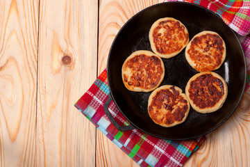 Beautiful golden cheese pancakes fried in a pan. Syrniki.