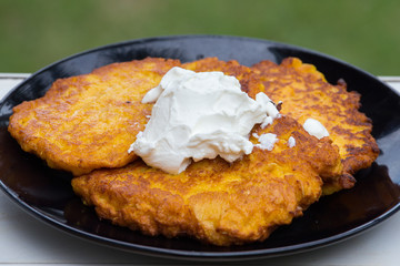 Potato and carrot pancakes with sour cream