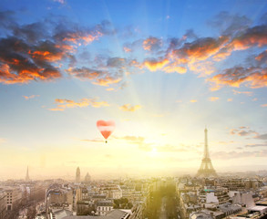 Fototapeta na wymiar Aerial View of Paris skyline and Eiffel tower at sunset with red balloon in form of heart. Counter light shot. Business, Love and travel concept