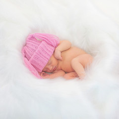 Newborn baby sleeps in a nest of blanket
