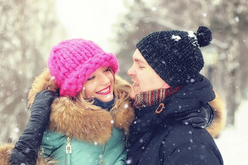 young couple man carries a girl winter