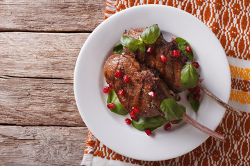 Grilled beef steak with pomegranate on a plate. Horizontal top view
