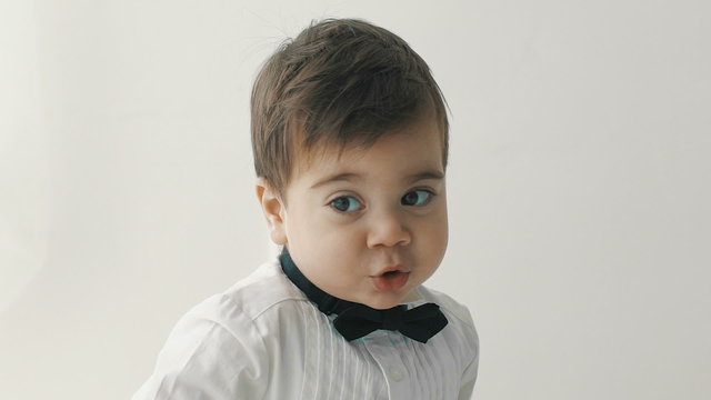 little cute boy in bowtie smiling, making funny faces, stylish casual kid