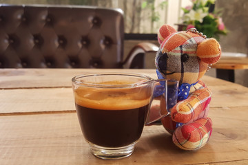 Coffee on wooden background and bear doll