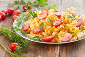 Macaroni pasta in vegetable sauce with fresh tomatoes and parsley on wooden dark background. Vegetarian o healthy food concept