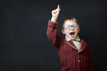 little boy in glasses raises his hand.concept ideas
