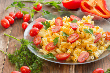 Macaroni pasta in vegetable sauce with fresh tomatoes and parsley on wooden dark background. Vegetarian o healthy food concept