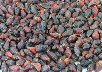 Pile of dried rose hips isolated on white
